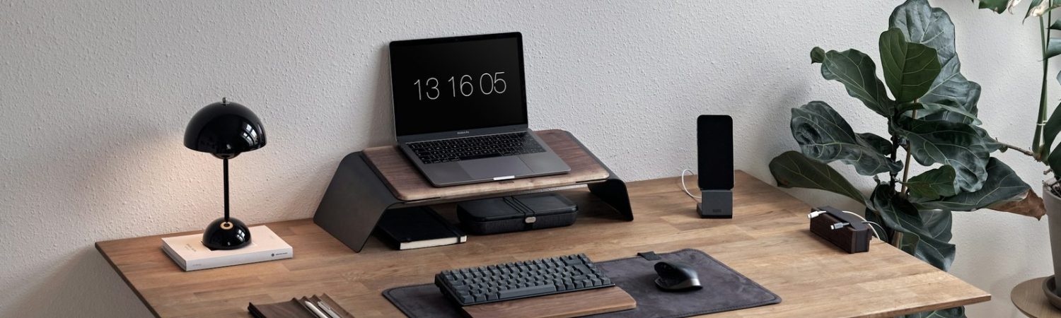 A calm laptop desk setup with a plant and keyboard