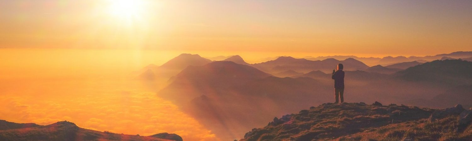 A person standing on a mountain at sunrise