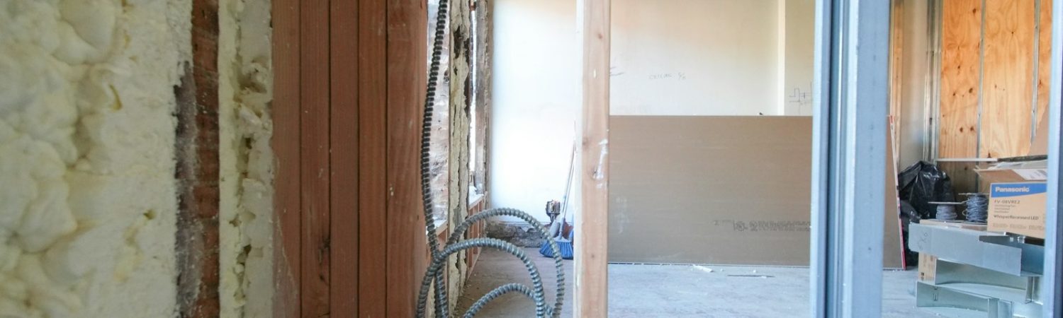 An unfinished room under renovation with exposed framing and wiring