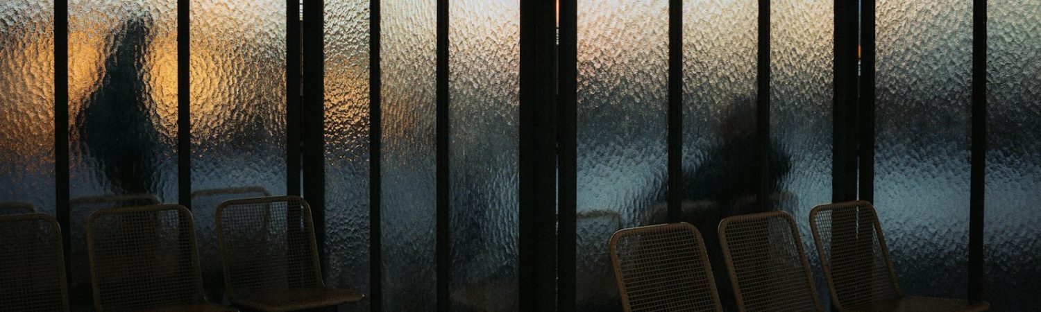Silhouettes in a waiting area at sunset