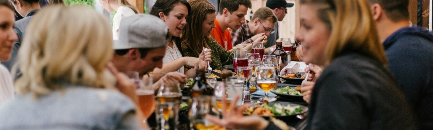 A group of people gathered around a long table in conversation
